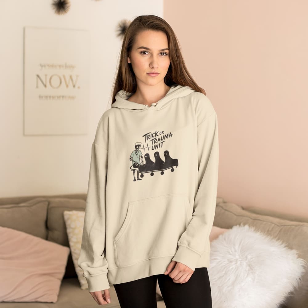 Woman wearing a beige hoodie with graphic design in a living room setting