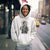 Person wearing a hoodie with a graphic design on a city street