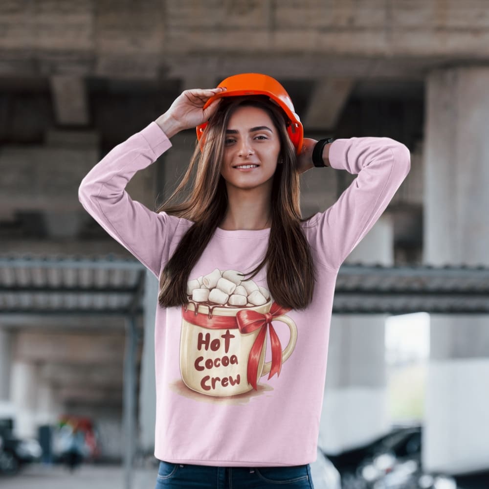Woman wearing a pink shirt with 'Hot Cocoa Crew' design and an orange hard hat.