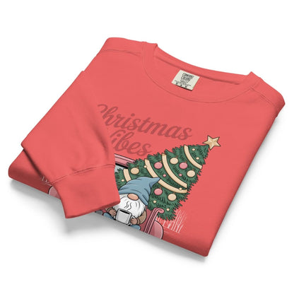 Folded red sweatshirt with Christmas tree and gnome design on a white background