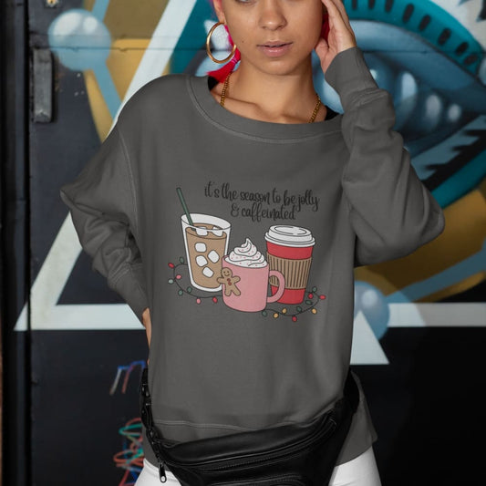 Person wearing a gray sweatshirt with coffee-themed design in front of a colorful mural.