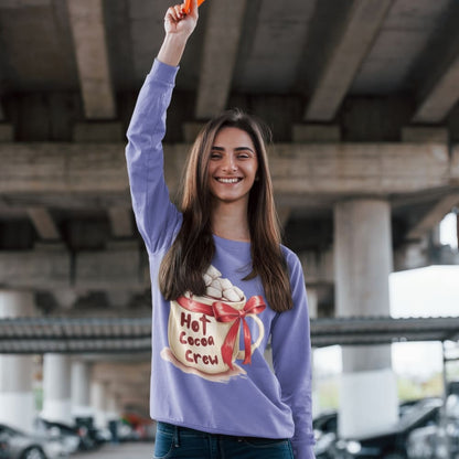 Woman wearing a purple sweatshirt with a hot cocoa design, standing under an overpass.