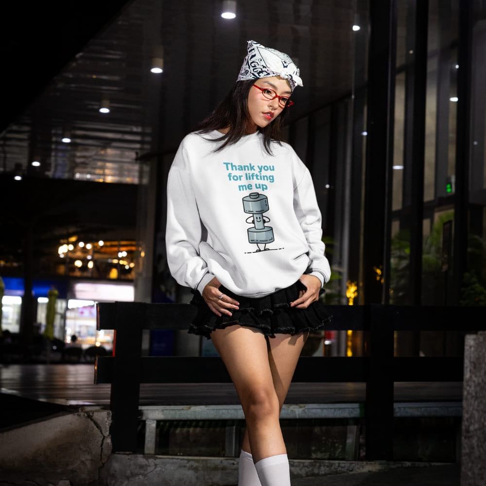 Person wearing a white sweatshirt with a graphic design, standing in an urban night setting.