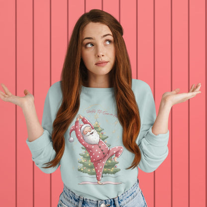 Woman wearing a light blue sweater with a Christmas-themed design against a pink wooden panel background