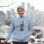 Person wearing a light blue hoodie with a graphic design in an urban setting