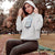 Person wearing a gray hoodie with a graphic design in a park