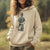 Person wearing a beige hoodie with a graphic design outdoors