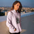 Person wearing a light purple hoodie with a spider graphic, standing on a rooftop with a cityscape in the background.