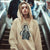 Person wearing a beige hoodie with a graphic design in an indoor setting