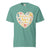 Teal t-shirt with a heart-shaped design featuring text and icons on a white background