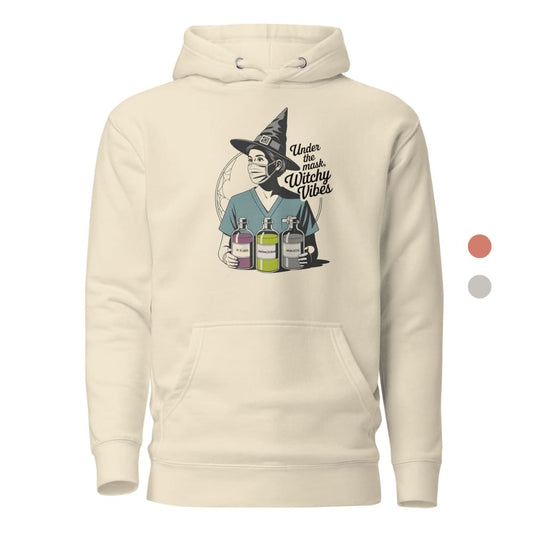 Beige hoodie with a graphic of a person in a witch hat holding potion bottles and text 'Under the Influence Witchy Vibes'.