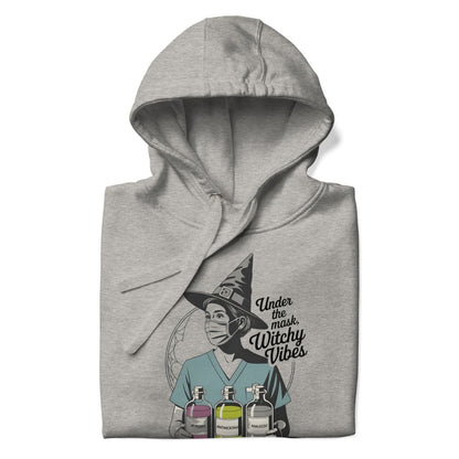 Gray hoodie with a graphic design of a person wearing a witch hat and text 'Under the mask, Witchy Vibes' on a white background.