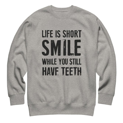 Gray sweatshirt with black text 'Life is short, smile while you still have teeth' on a white background