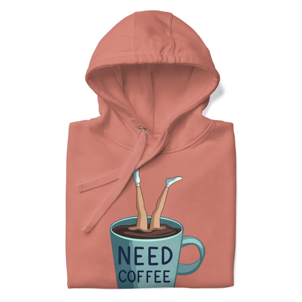 Folded peach-colored hoodie with a graphic of legs in a coffee cup and 'NEED COFFEE' text on a white background.