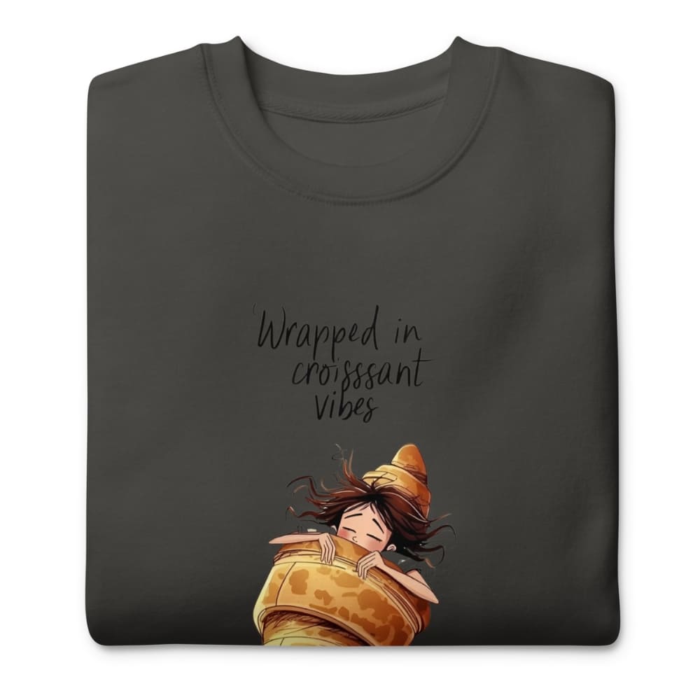 Black t-shirt with an illustration of a person wrapped in a croissant and text 'Wrapped in croissant vibes' on a white background.