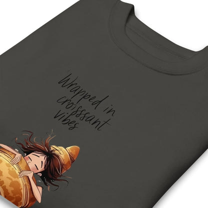 Black t-shirt with a graphic of a person wrapped in a croissant and text 'Wrapped in croissant vibes' on a white background.