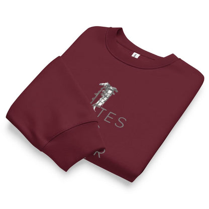 Folded maroon sweatshirt with a graphic design on a white background