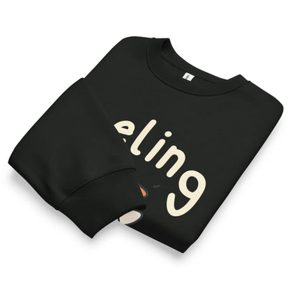 Black sweatshirt with 'eling' printed on it, folded neatly on a white background