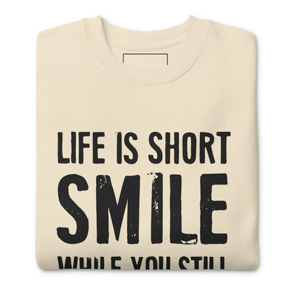 Beige sweatshirt with 'Life is short, smile while you still can' text on a white background