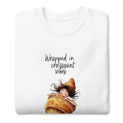 White t-shirt with cartoon character wrapped in a croissant and text 'Wrapped in croissant vibes' on a white background