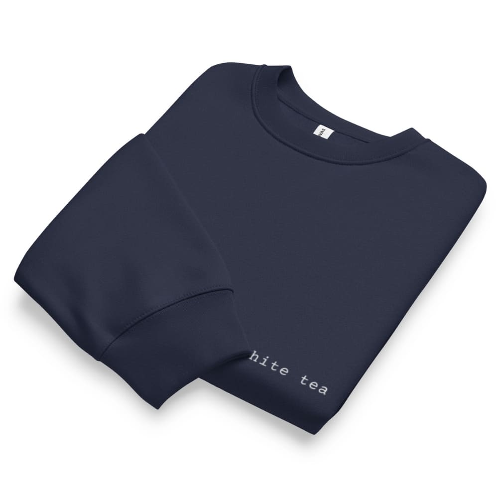Folded navy blue sweatshirt with 'hite tea' text on a white background