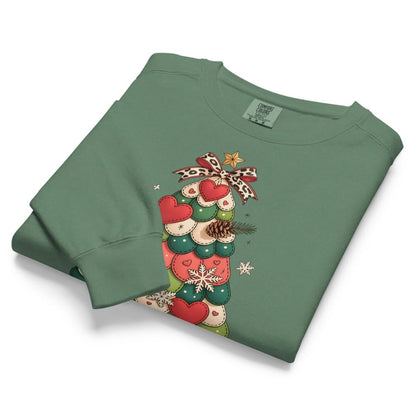 Folded green sweatshirt with Christmas tree design on a white background