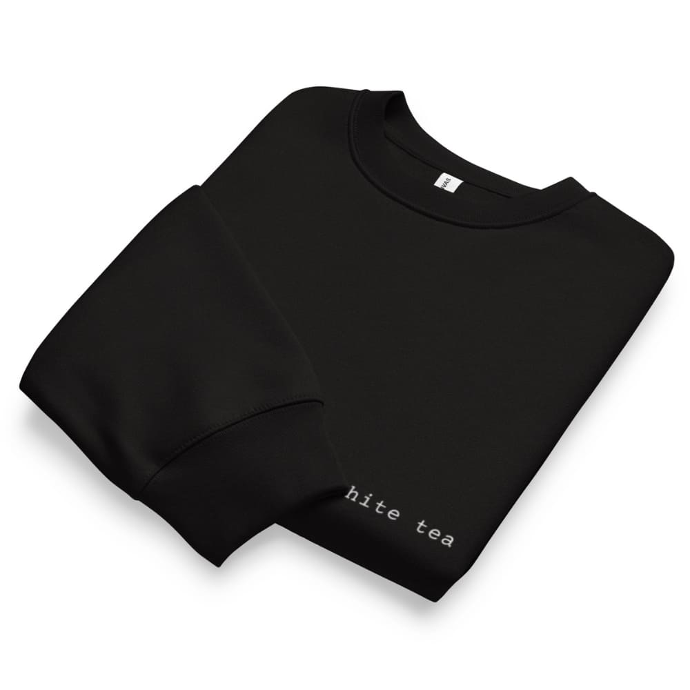 Folded black sweatshirt with 'hite tea' text on a white background