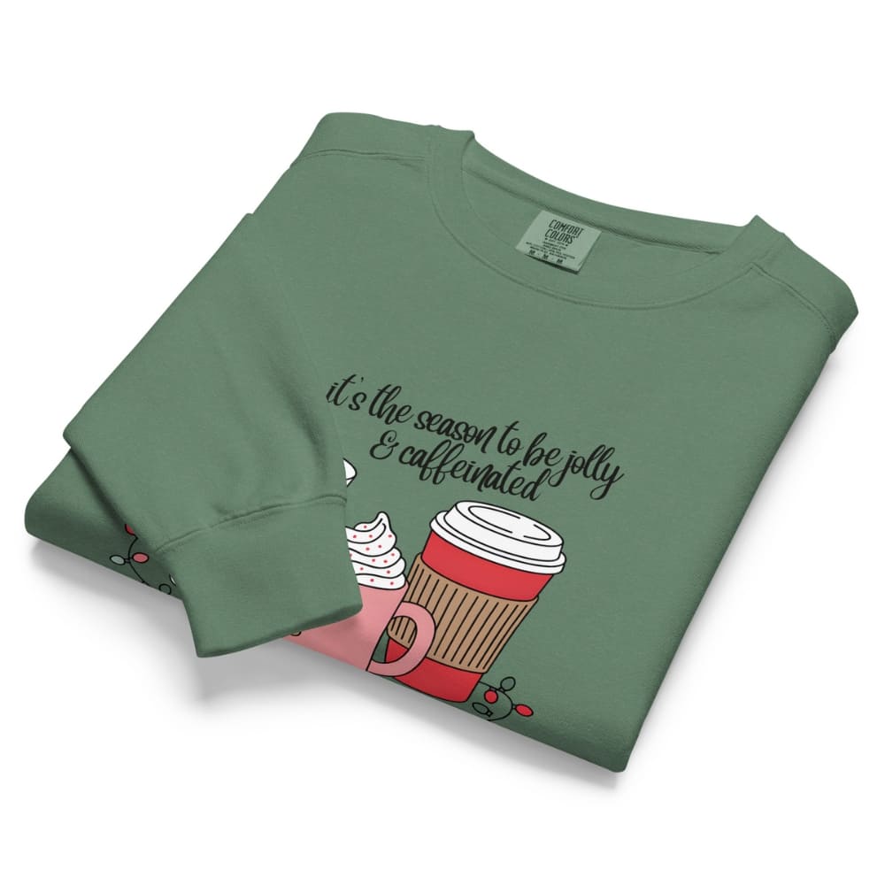 Folded green sweatshirt with a coffee cup graphic and text on a white background