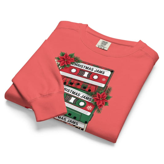 Folded red sweatshirt with Christmas-themed cassette tape design on a white background