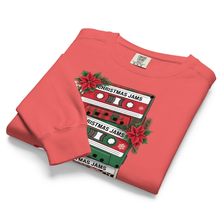 Folded red sweatshirt with Christmas-themed cassette tape design on a white background