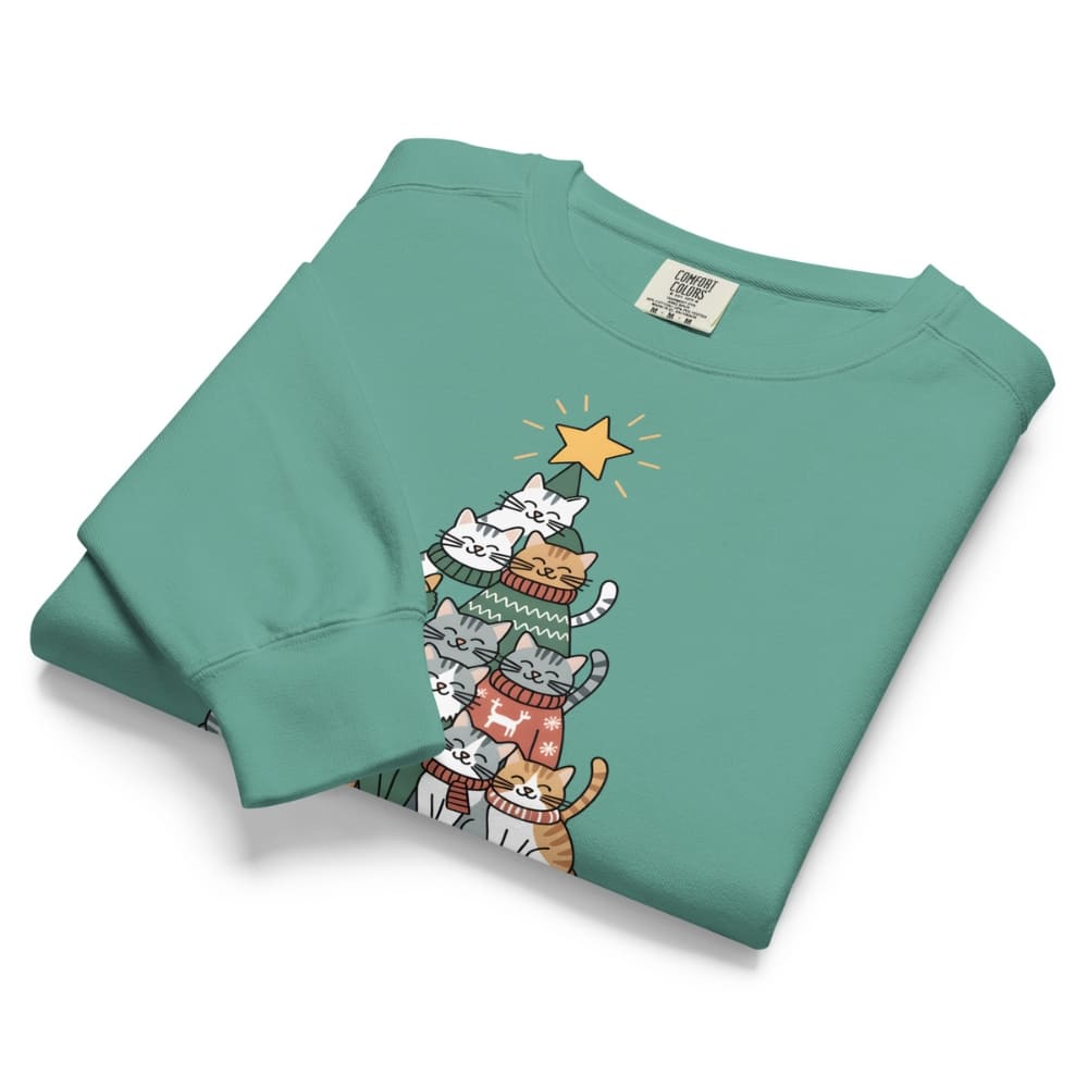 Folded teal sweatshirt with cartoon cats design on a white background