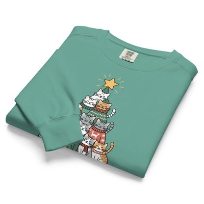 Folded teal sweatshirt with cartoon cats design on a white background