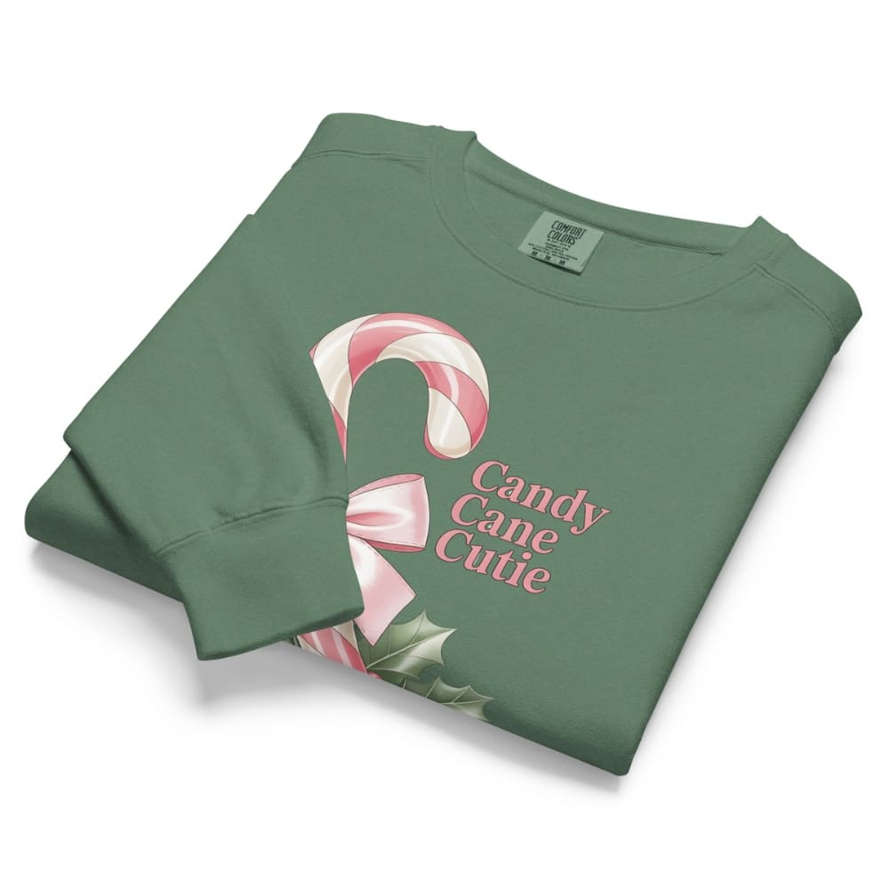 Folded green sweatshirt with candy cane design and 'Candy Cane Cutie' text on a white background