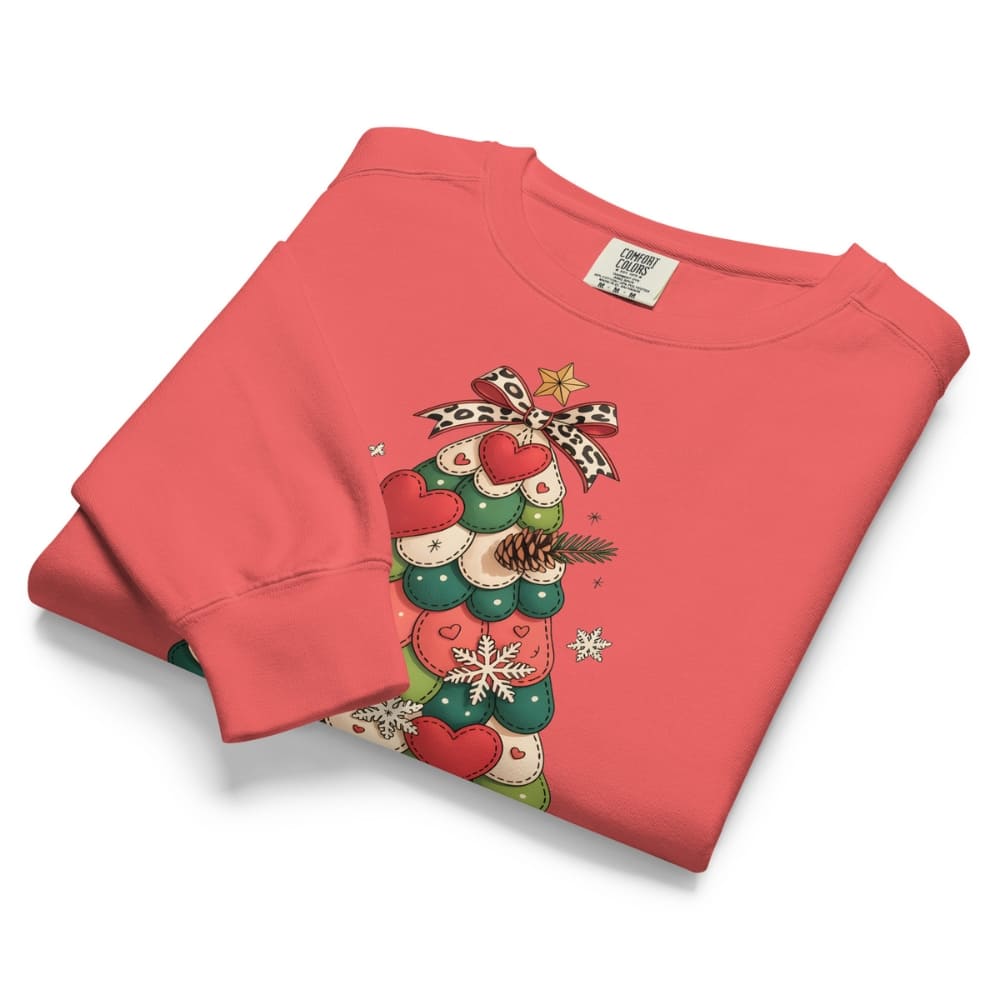 Folded red sweatshirt with Christmas tree design on a white background