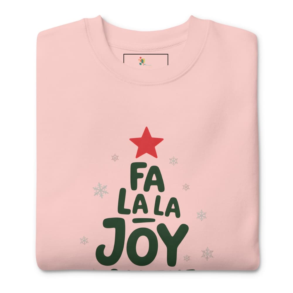 Folded pink sweatshirt with 'Fa La La Joy' text and red star design on a white background