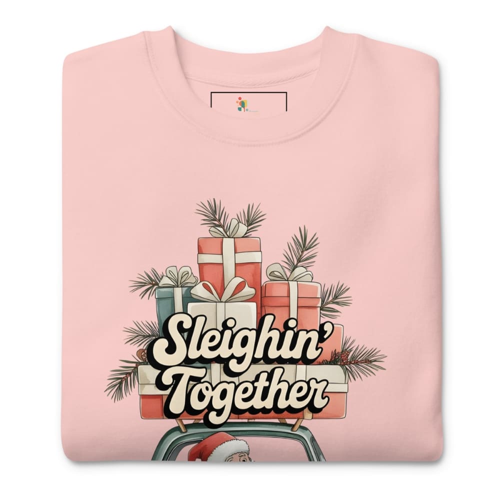 Pink sweatshirt with Christmas-themed design featuring presents and 'Sleighin' Together' text on a white background.