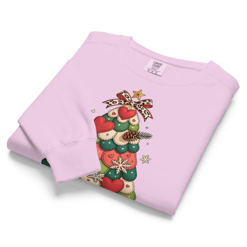 Folded pink sweatshirt with Christmas-themed design on a white background