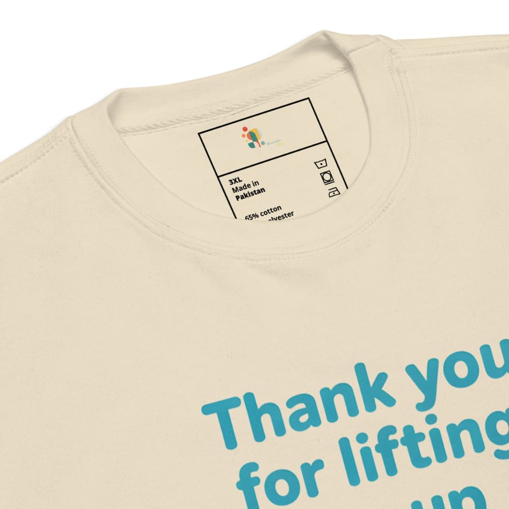 Beige sweatshirt with blue text 'Thank you for lifting us up' and a label on the collar.