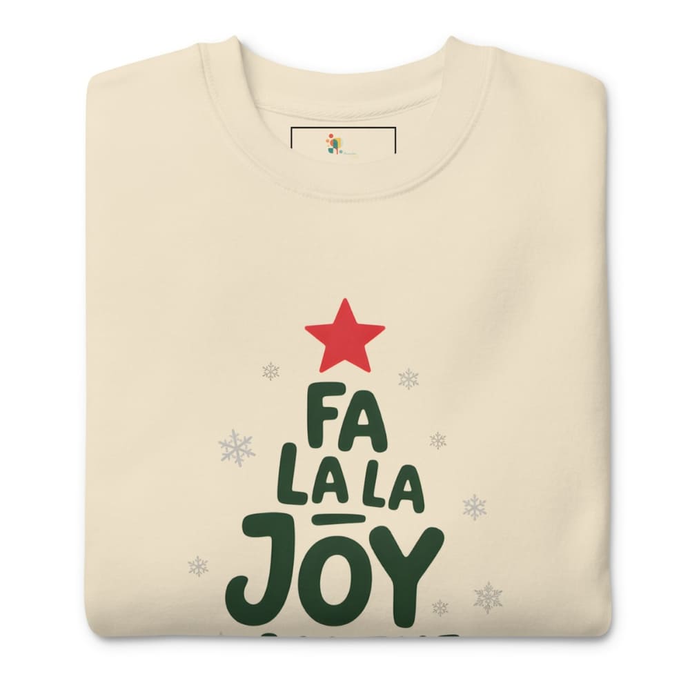 Folded cream sweatshirt with 'Fa La La Joy' text and red star on a white background
