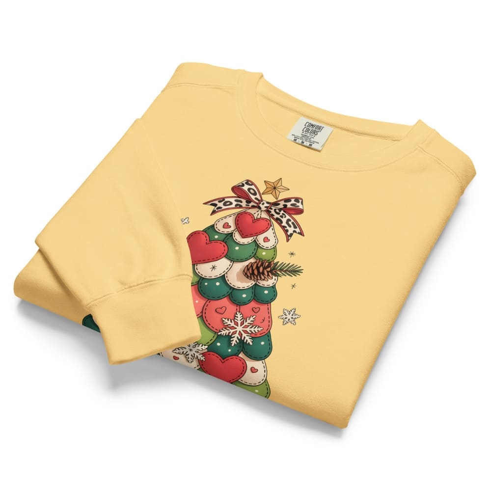 Folded yellow sweatshirt with Christmas-themed design on a white background