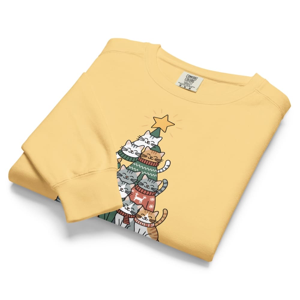 Folded yellow sweatshirt with a graphic of cats in sweaters on a white background