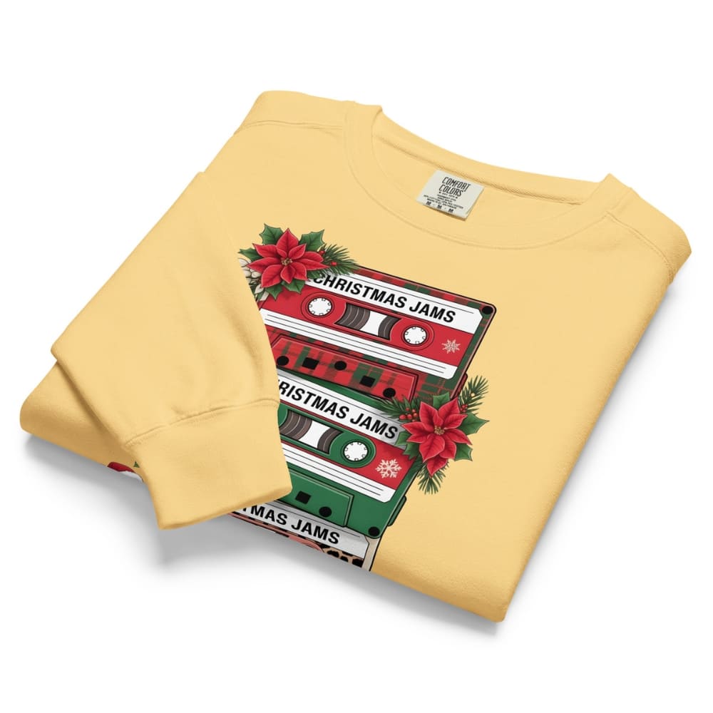 Folded yellow sweatshirt with Christmas-themed cassette tape design on a white background