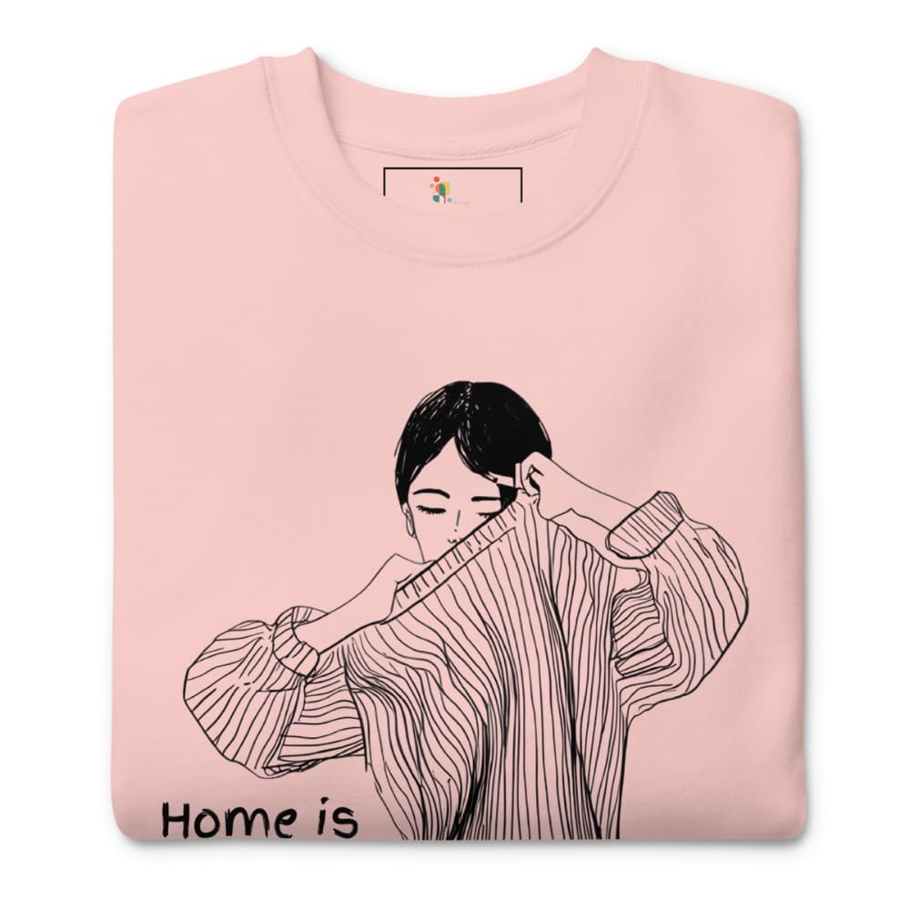 Pink sweatshirt with a black and white illustration of a person wearing a sweater and 'Home is' text on a white background