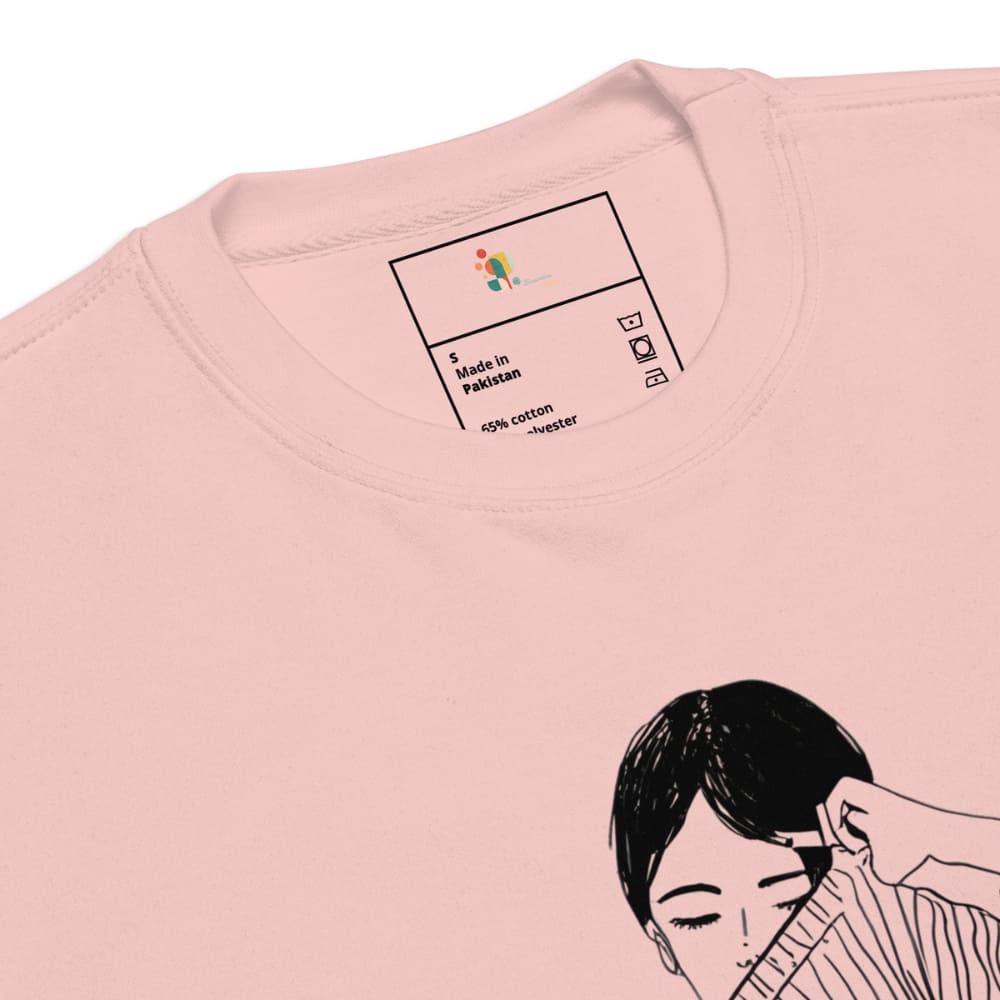 Close-up of a pink t-shirt with a label and an illustration of a woman on a white background