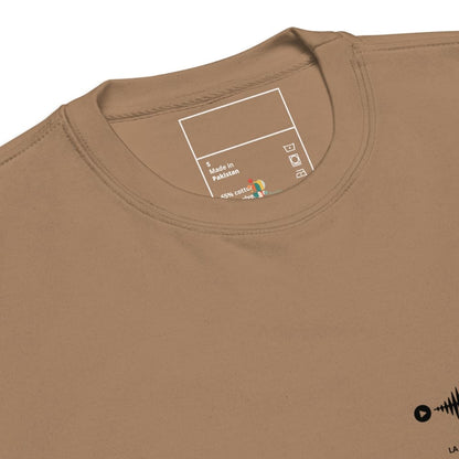 Close-up of a brown t-shirt with a label on the collar and a small logo on the sleeve.