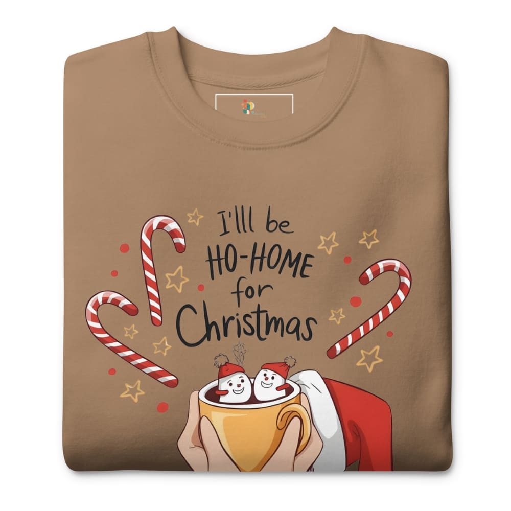 Folded brown t-shirt with Christmas-themed design featuring candy canes, stars, and a cup of hot chocolate.