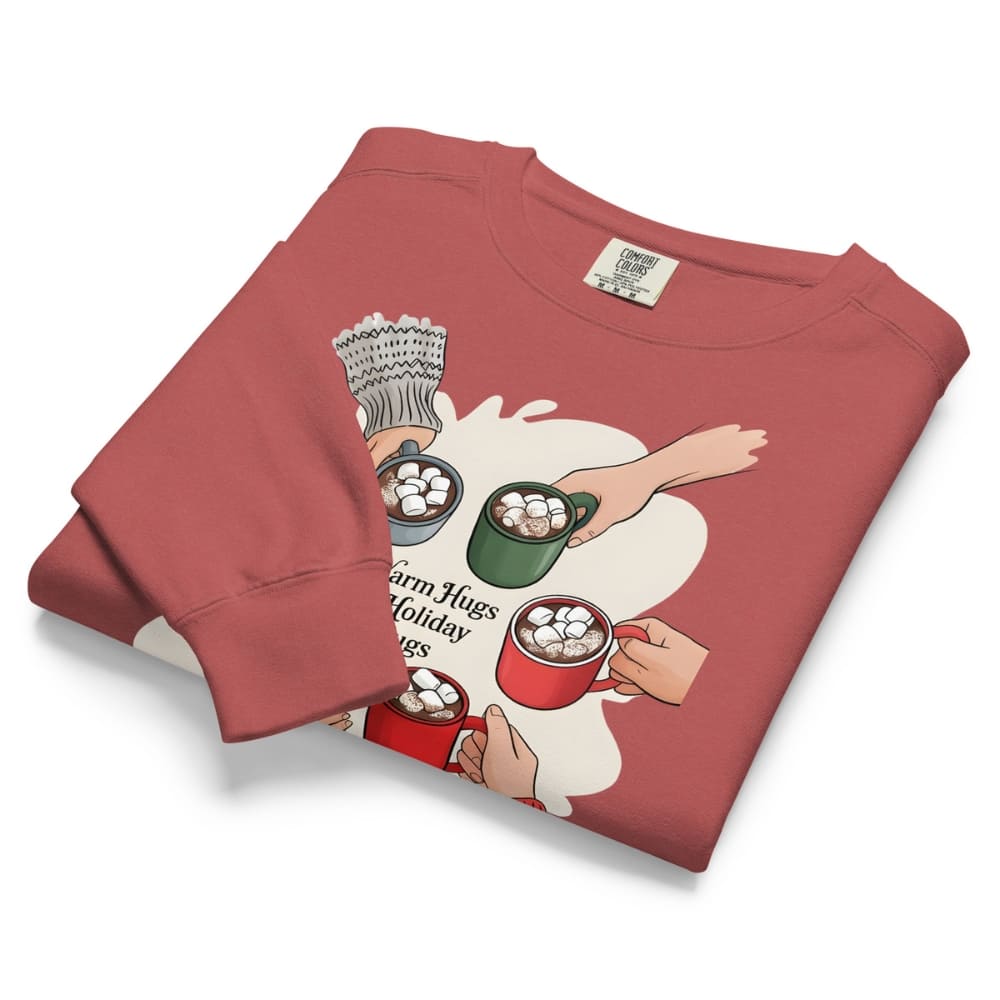 Folded red sweatshirt with graphic design of people holding hot cocoa mugs on a white background