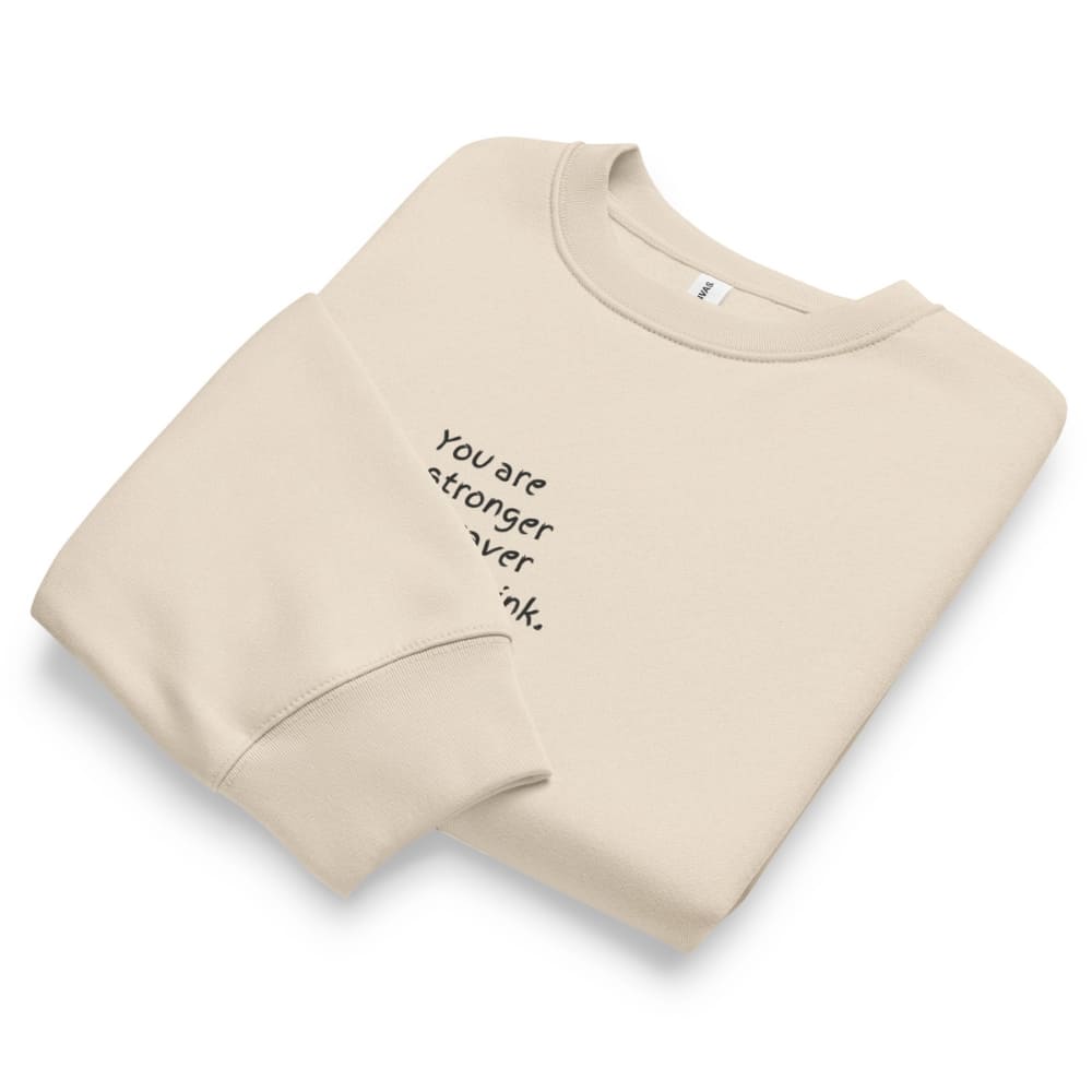 Beige sweatshirt with motivational text on a white background