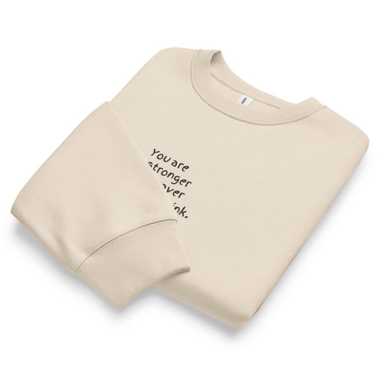 Beige sweatshirt with motivational text on a white background