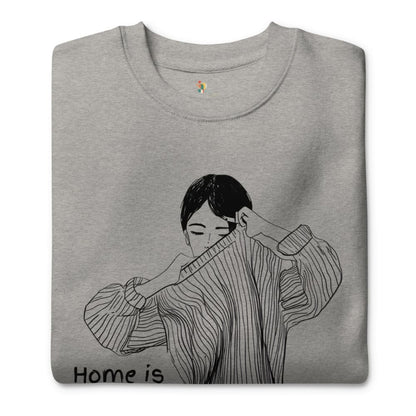 Gray sweatshirt with a black and white illustration of a person wearing a sweater, with 'Home is' text at the bottom.